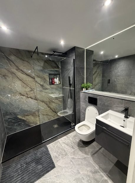 Dark grey marble wet room with walk-in shower, wall hung WC and vanity