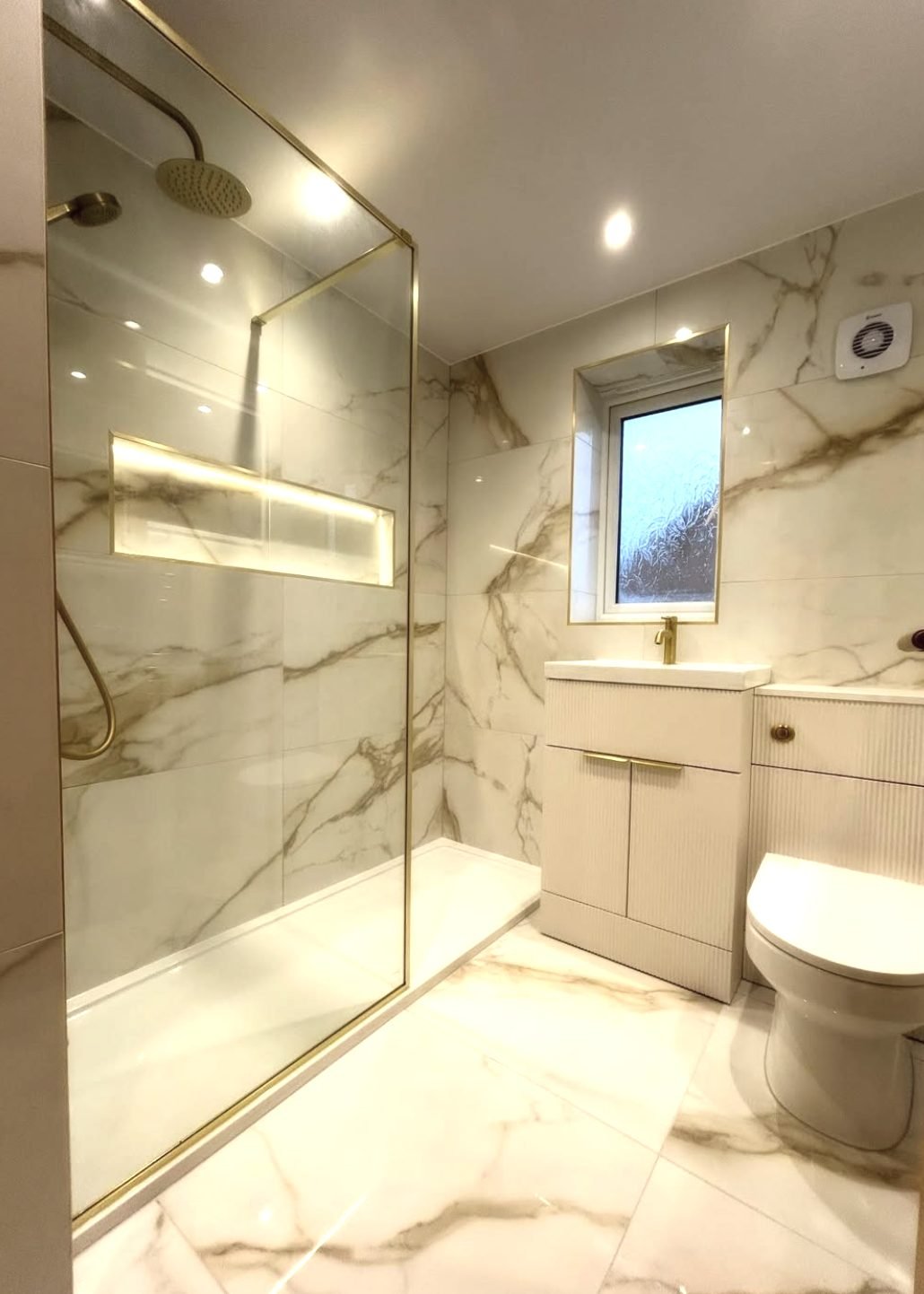 Marble-effect bathroom with brushed brass walk-in shower screen, fitted in Barnsley